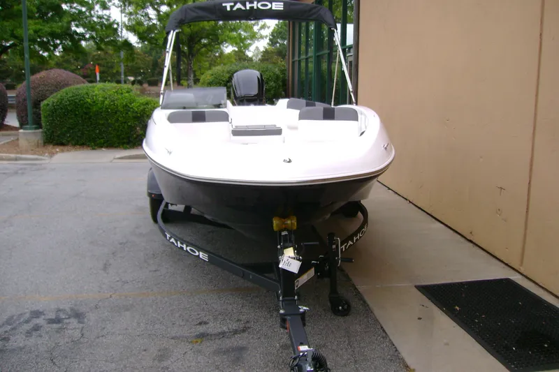 Slide: The Image of 2027 Tahoe T16 boat on trailer, parked outdoors near building. - 6