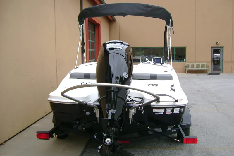 Slide: The Image of 2027 Tahoe T16 boat with outboard motor, parked on a trailer near a building. - 7