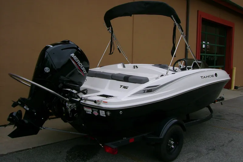 Slide: The Image of 2027 Tahoe T16 boat with Mercury engine, parked outdoors on a trailer. - 4