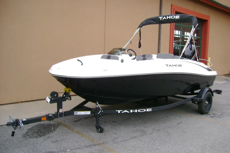 Slide: The Image of 2027 Tahoe T16 boat on trailer, black and white design, parked outdoors. - 3