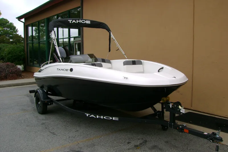 Slide: The Image of 2027 Tahoe T16 boat on trailer, parked near a building. - 2