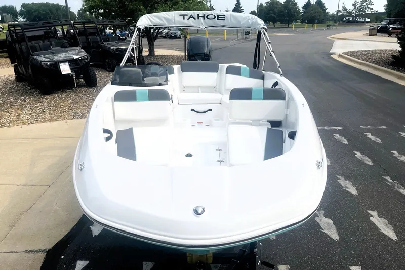 Slide: The Image of 2027 Tahoe T16 boat with sleek white design, parked outdoors. - 2