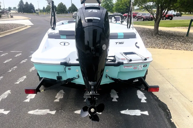 Slide: The Image of 2027 Tahoe T16 boat with Mercury 75 engine on a trailer, parked outdoors. - 6