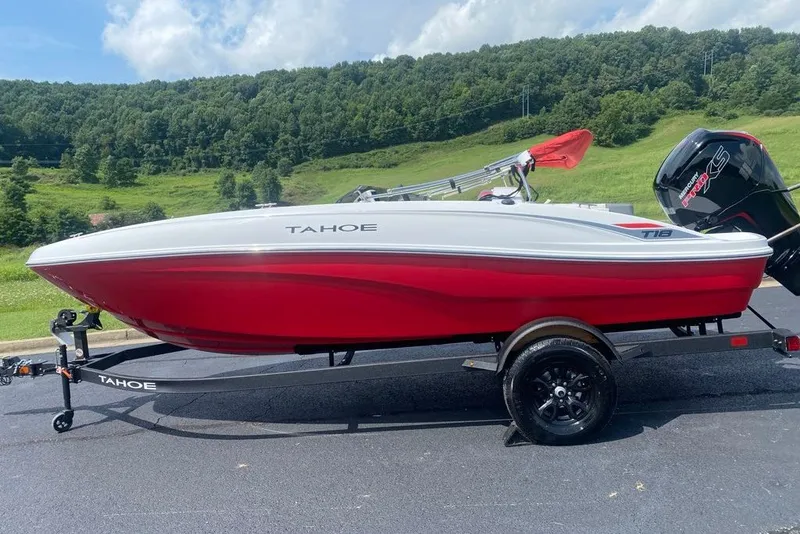 Slide: The Image of 2027 Tahoe T18 boat on trailer, red and white design, parked outdoors with scenic background. - 4