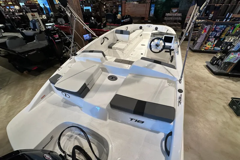 Slide: The Image of 2027 Tahoe T18 boat interior with seating and steering wheel in showroom. - 7