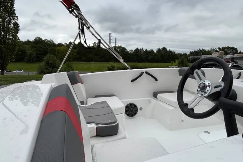 Slide: The Image of 2027 Tahoe T18 boat interior with steering wheel, seating, and overcast sky. - 69