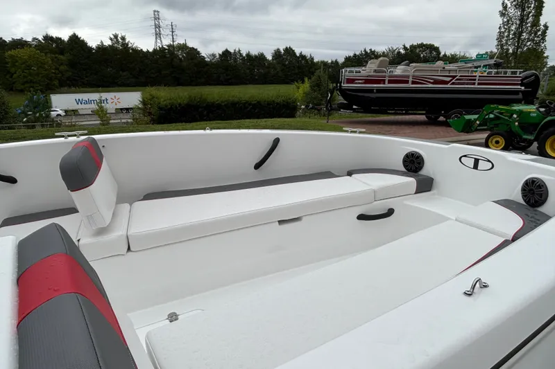 Slide: The Image of 2027 Tahoe T18 boat interior with white and gray seating, parked outdoors. - 68