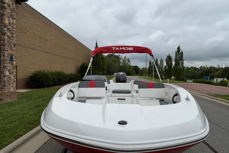 Slide: The Image of 2027 Tahoe T18 boat with red canopy parked outdoors on a cloudy day. - 66