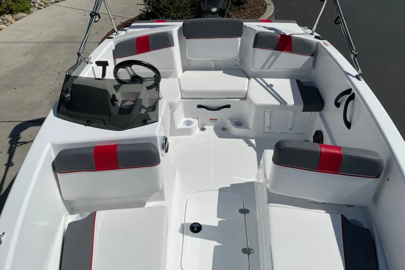 Slide: The Image of 2027 Tahoe T16 boat interior with gray and red seating, steering wheel, and dashboard. - 21