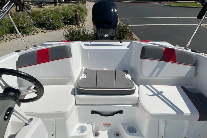 Slide: The Image of 2027 Tahoe T16 boat interior with white and red seating, steering wheel, and motor. - 8