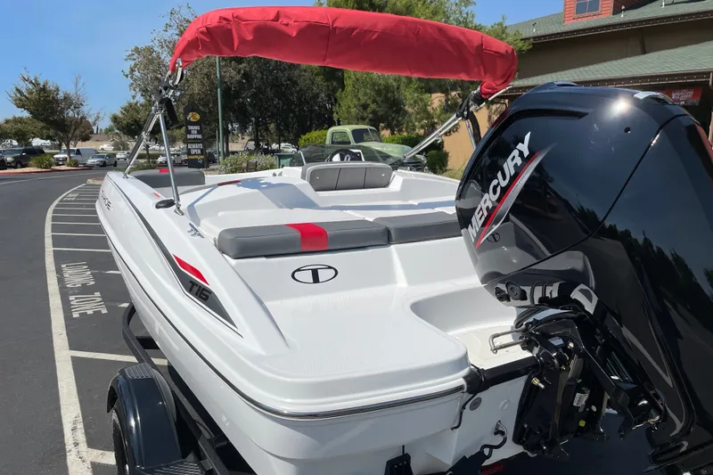 Slide: The Image of 2027 Tahoe T16 boat with Mercury engine, parked outdoors, featuring red canopy and sleek design. - 4