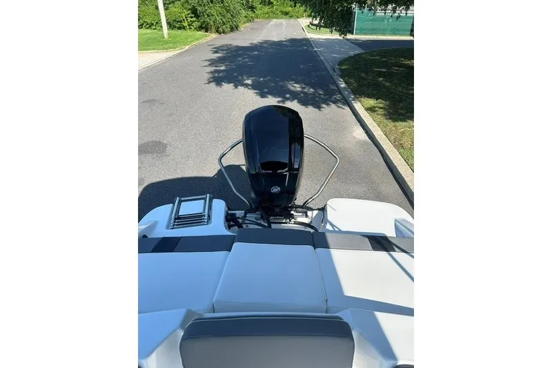 Slide: The Image of 2027 Tahoe T16 boat on a trailer, parked on a sunny street. - 8