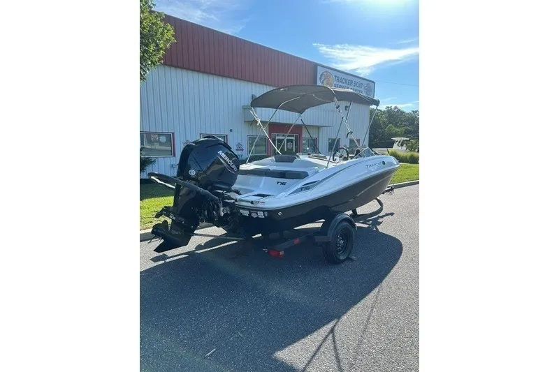 Slide: The Image of 2027 Tahoe T16 boat with outboard motor on trailer, parked outside a dealership. - 6