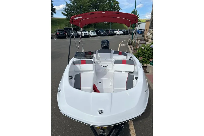 Slide: The Image of 2027 Tahoe T16 boat with red canopy, parked outdoors. - 3