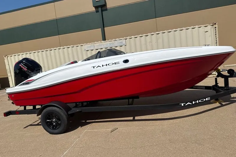 The Image of 2027 Tahoe T18 boat in red and white on a trailer, parked outdoors. - 0