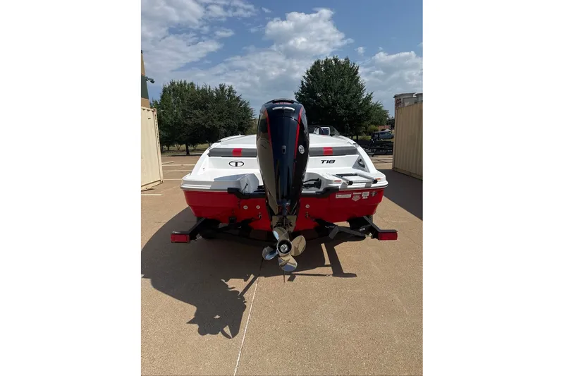 Slide: The Image of 2027 Tahoe T18 boat with outboard motor, parked outdoors on a sunny day. - 13