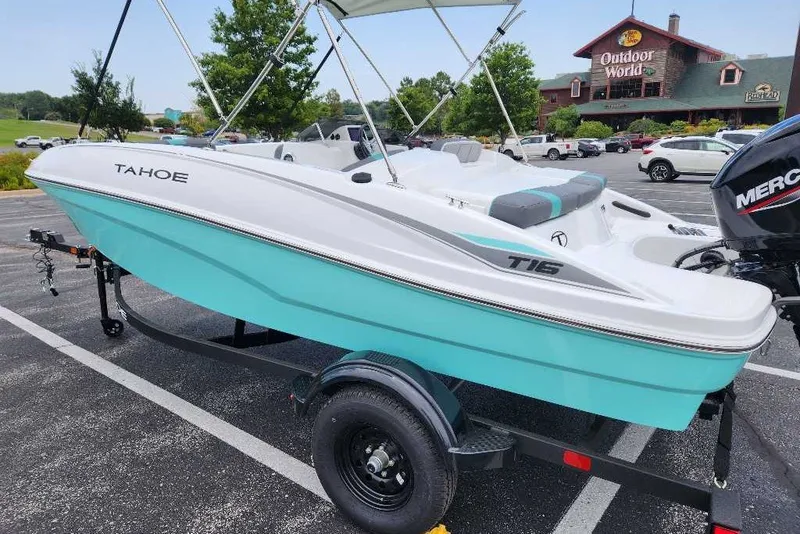 Slide: The Image of 2027 Tahoe T16 boat with turquoise hull on trailer in parking lot. - 14