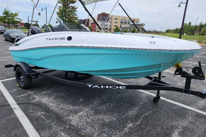 Slide: The Image of 2027 Tahoe T16 boat with turquoise hull on trailer in parking lot. - 12