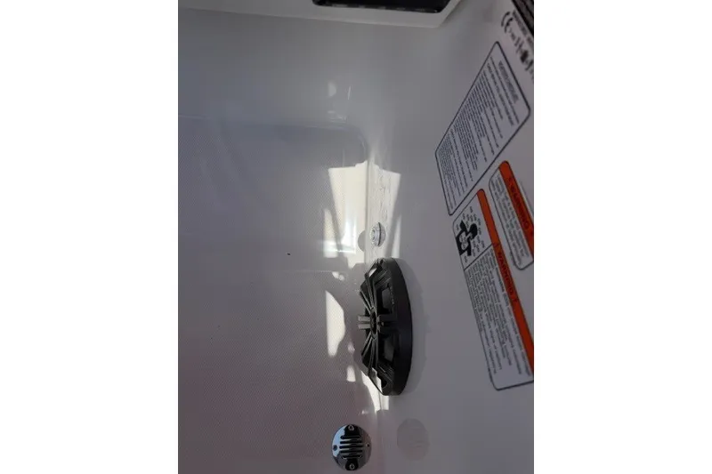 Slide: The Image of Interior view of a 2027 Tahoe T18 boat with warning labels and a drain plug. - 19
