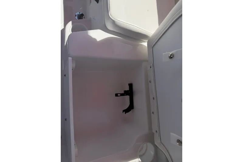 Slide: The Image of Open storage compartment in 2027 Tahoe T18 boat, featuring white interior and latch mechanism. - 16