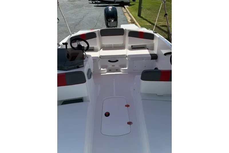 Slide: The Image of 2027 Tahoe T18 boat interior with seating and steering wheel, parked on pavement. - 18