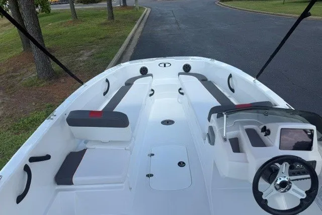 Slide: The Image of 2027 Tahoe T18 boat interior with seating and steering wheel, parked on a paved road. - 9