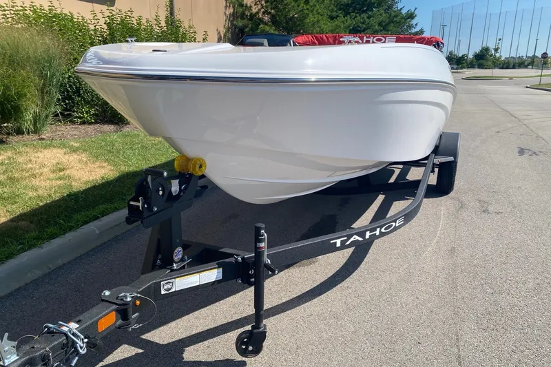 Slide: The Image of 2027 Tahoe T18 boat on trailer, parked outdoors on a sunny day. - 2