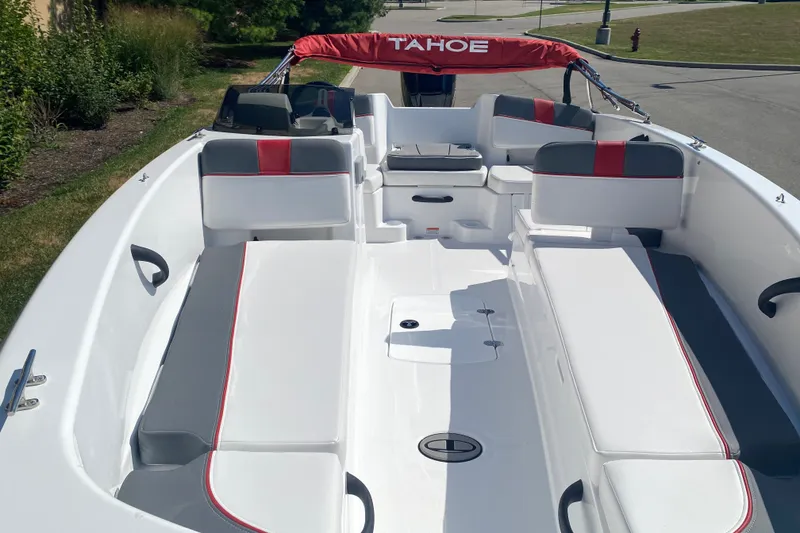 Slide: The Image of 2027 Tahoe T18 boat interior with red and gray seating, parked on a sunny day. - 3