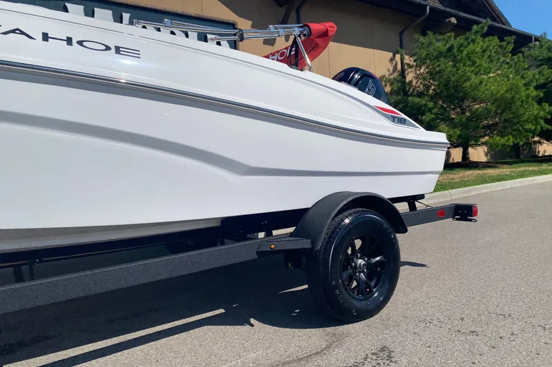 Slide: The Image of 2027 Tahoe T18 boat on trailer, parked outdoors, showcasing sleek white design. - 5