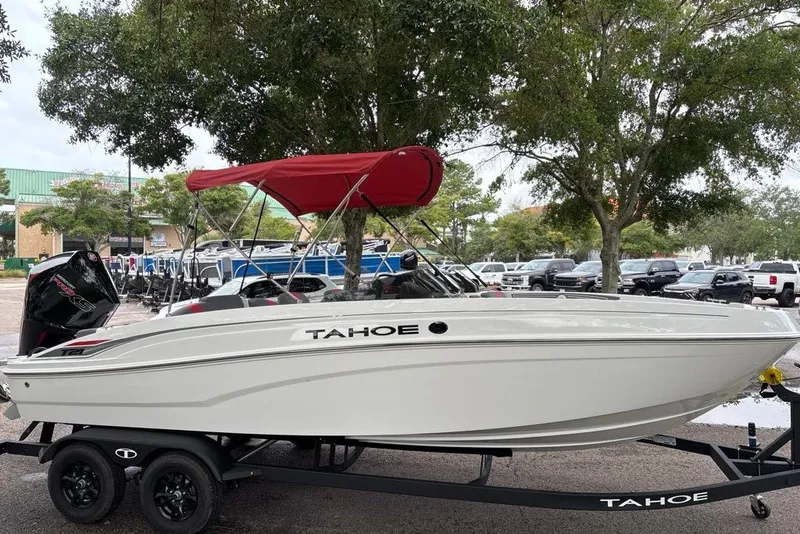 Slide: The Image of 2027 Tahoe T21 boat with red canopy on trailer, parked outdoors. - 4
