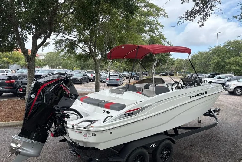 Slide: The Image of 2027 Tahoe T21 boat with red canopy on trailer in parking lot. - 3