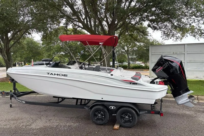 The Image of 2027 Tahoe T21 boat with red canopy on trailer, parked outdoors. - 0