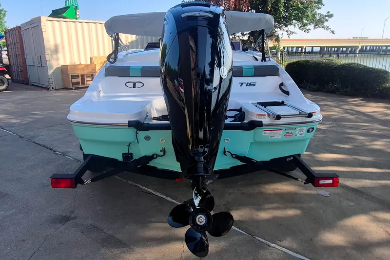 Slide: The Image of 2027 Tahoe T16 boat with outboard motor on a trailer, parked outdoors. - 6