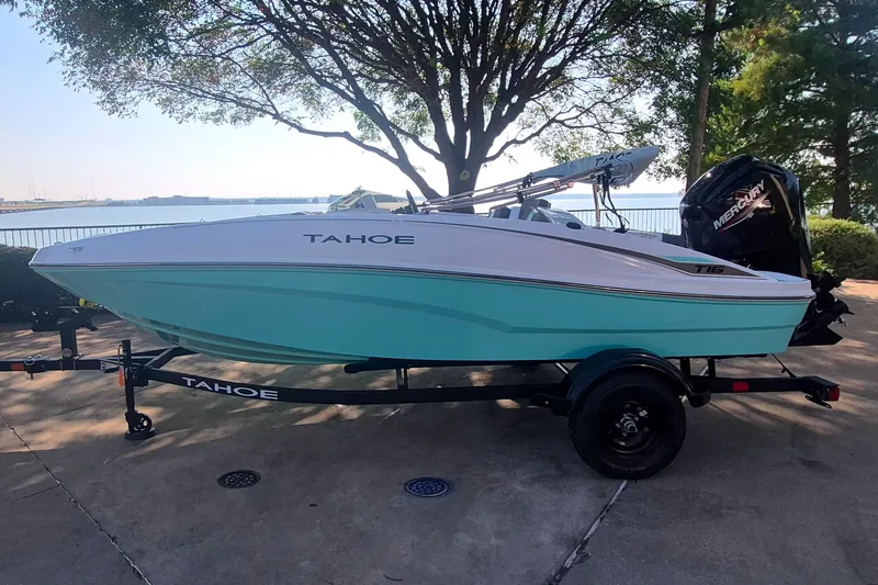 The Image of 2027 Tahoe T16 boat on trailer by lakeside, featuring sleek design and vibrant colors. - 0