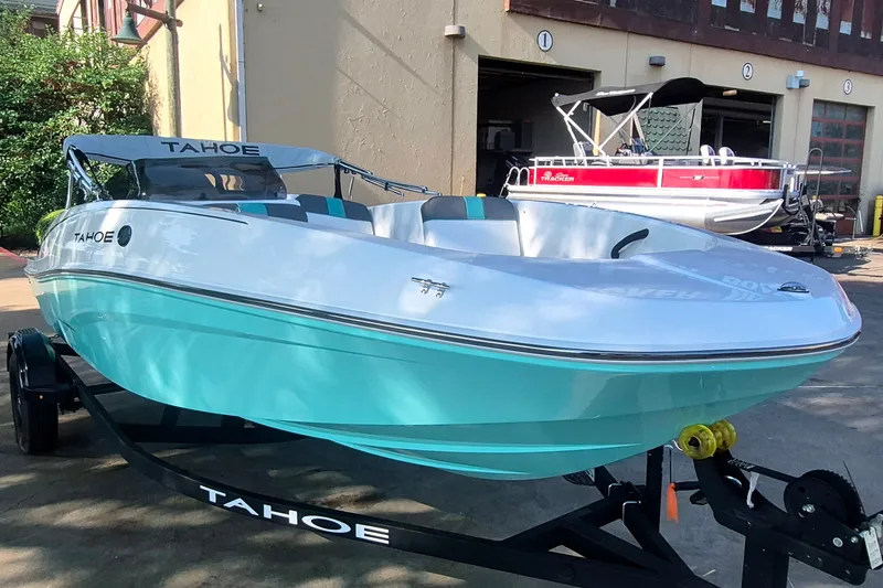 Slide: The Image of 2027 Tahoe T16 boat with turquoise hull on a trailer, parked outdoors. - 3