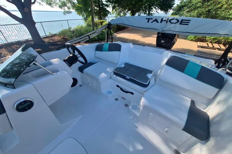 Slide: The Image of 2027 Tahoe T16 boat interior with sleek seating and modern steering, near a scenic waterfront. - 11