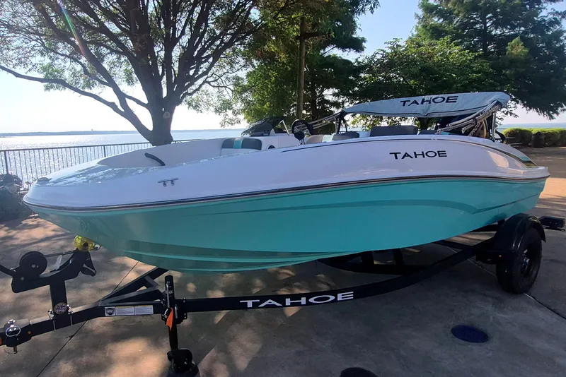 Slide: The Image of 2027 Tahoe T16 boat on trailer by lakeside, featuring sleek design and turquoise hull. - 1