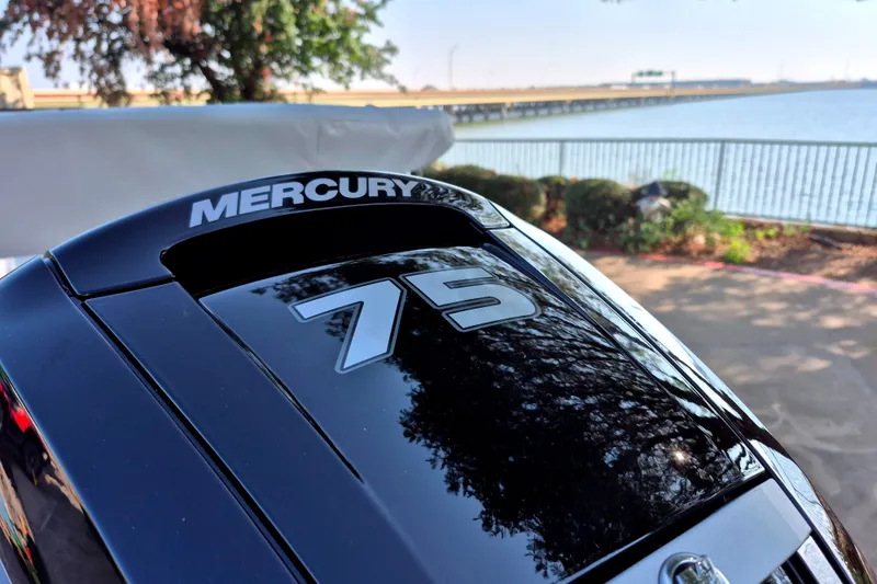 Slide: The Image of Mercury 75 outboard motor on a 2027 Tahoe T16 boat by a lakeside. - 14