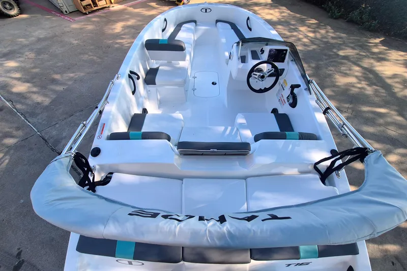 Slide: The Image of 2027 Tahoe T16 boat interior with seating and steering wheel, parked on concrete. - 8