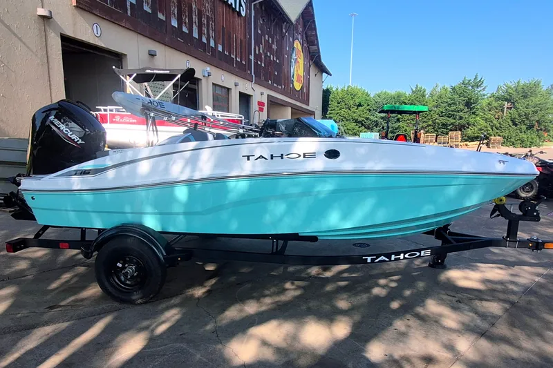 Slide: The Image of 2027 Tahoe T16 boat in light blue on trailer, parked outside a building. - 4