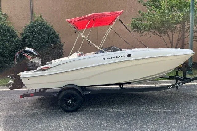 The Image of 2027 Tahoe T18 boat with red canopy on trailer, parked outdoors. - 0