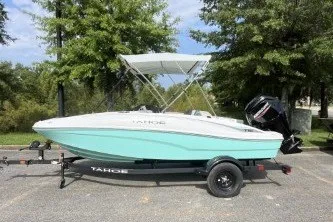 The Image of 2027 Tahoe T16 boat on trailer, parked outdoors with trees in background. - 0