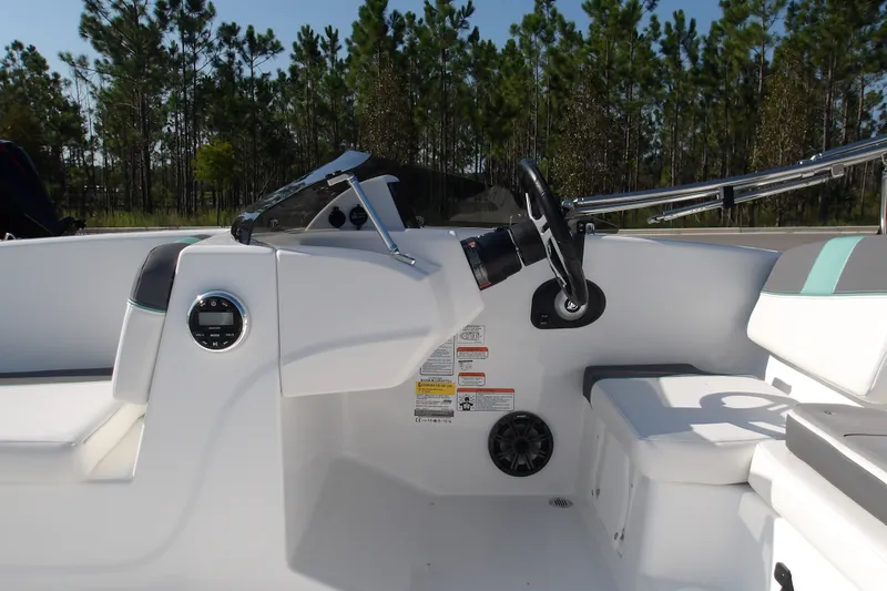 Slide: The Image of 2027 Tahoe T16 boat cockpit with steering wheel and control panel, surrounded by trees. - 17