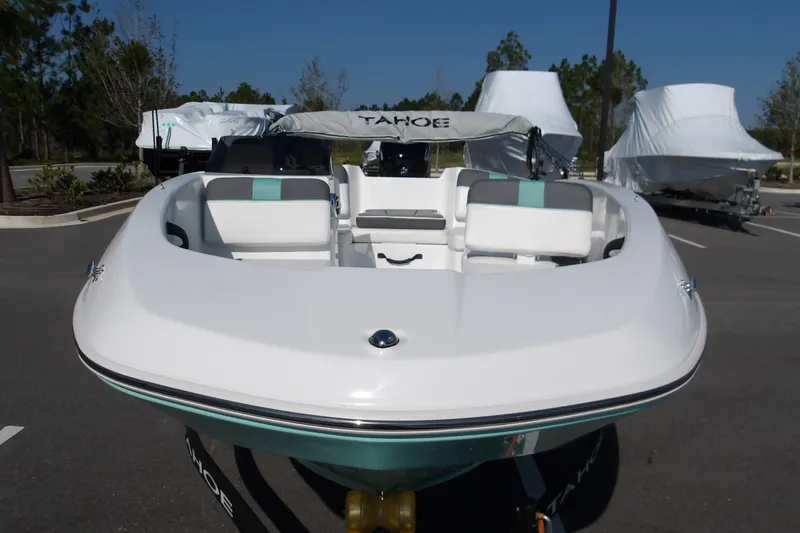 Slide: The Image of 2027 Tahoe T16 boat in parking lot, front view with covered boats in background. - 15