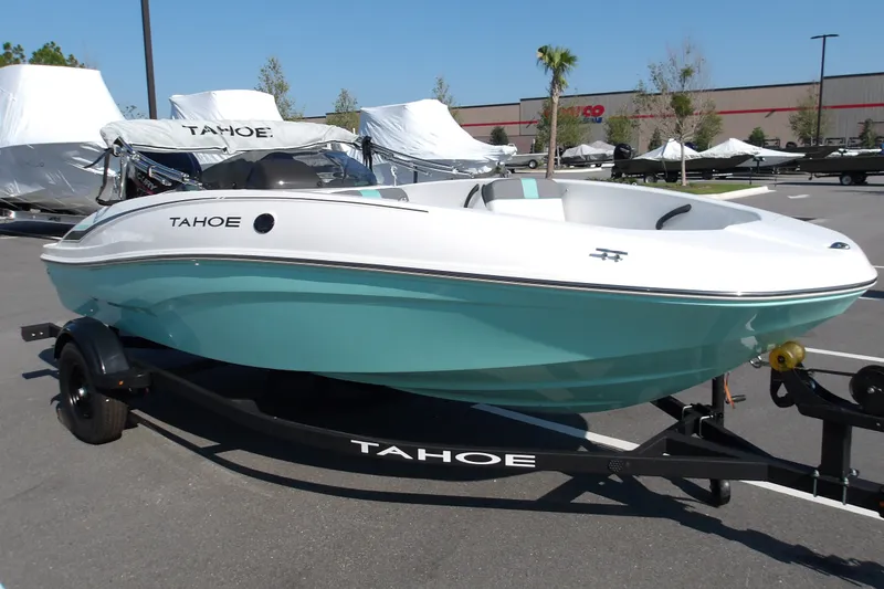 Slide: The Image of 2027 Tahoe T16 boat on trailer, turquoise and white design, parked outdoors. - 2