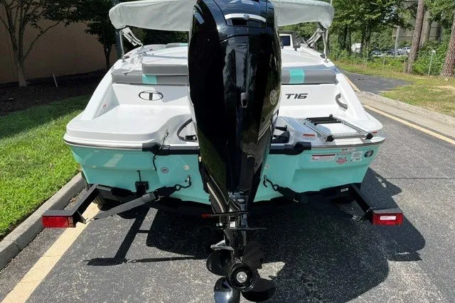 Slide: The Image of 2027 Tahoe T16 boat with outboard motor on a trailer, parked outdoors. - 3