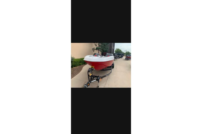 Slide: The Image of 2027 Tahoe T21 boat on trailer, red and white design, parked outdoors. - 1