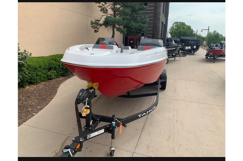 Slide: The Image of 2027 Tahoe T21 boat on trailer, red and white design, parked outdoors. - 1