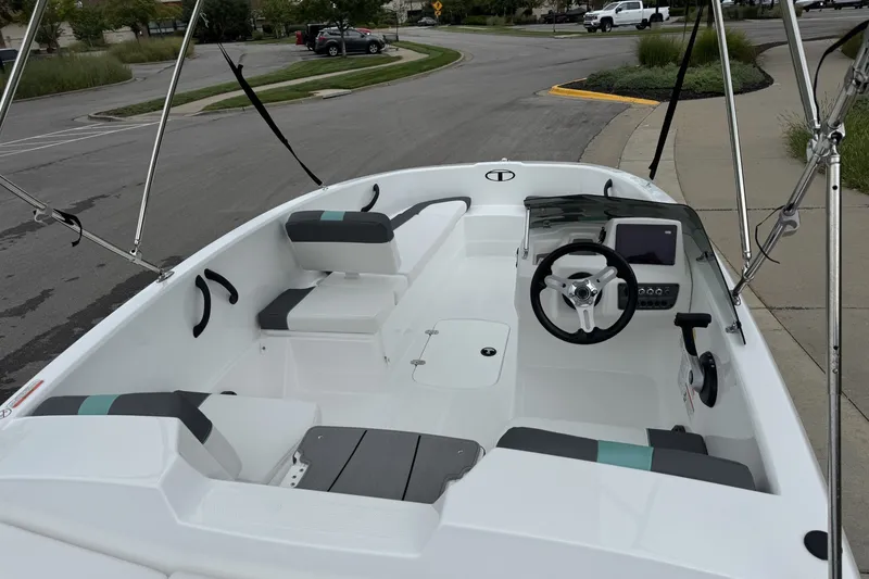 Slide: The Image of 2027 Tahoe T16 boat interior with steering wheel, seating, and dashboard in a parking area. - 16