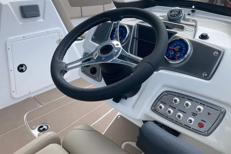 Slide: The Image of Steering wheel and dashboard of a 2027 Tahoe 1950 boat, featuring gauges and controls. - 3